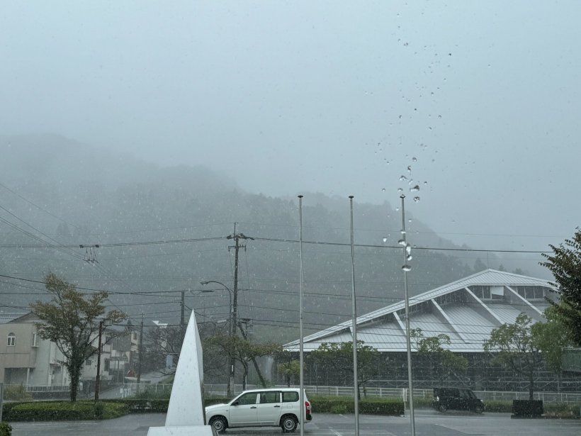 山に雲がかかり雨が降っている